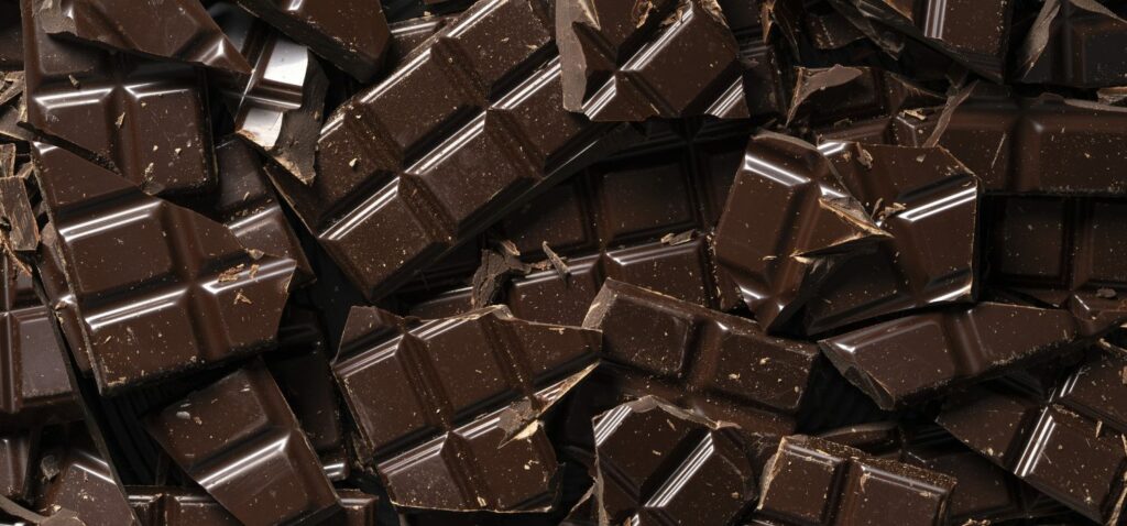 Dunkle Schokolade ist in Bruchstücken übereinander gestapelt und aus der Draufsicht fotografiert