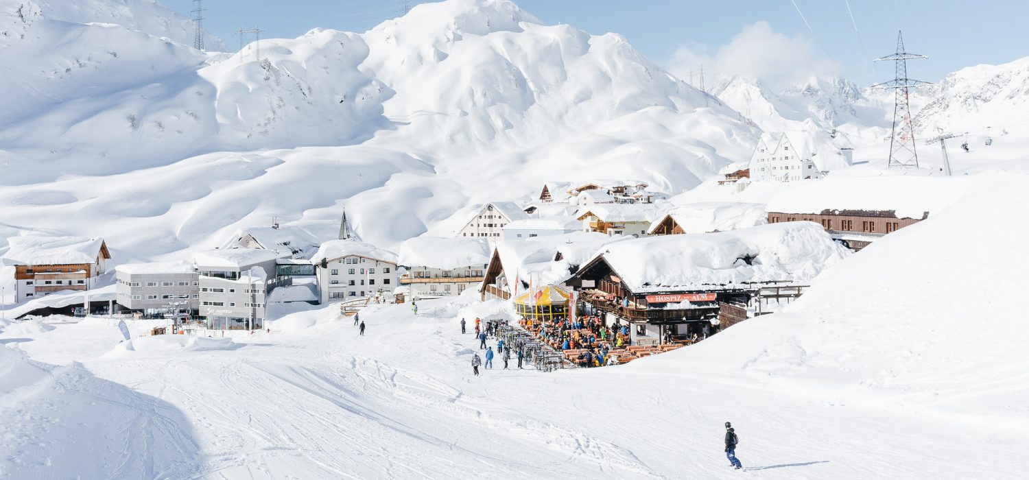 Eine Skihütte in verschneiter Berglandschaft, blauer Himmel